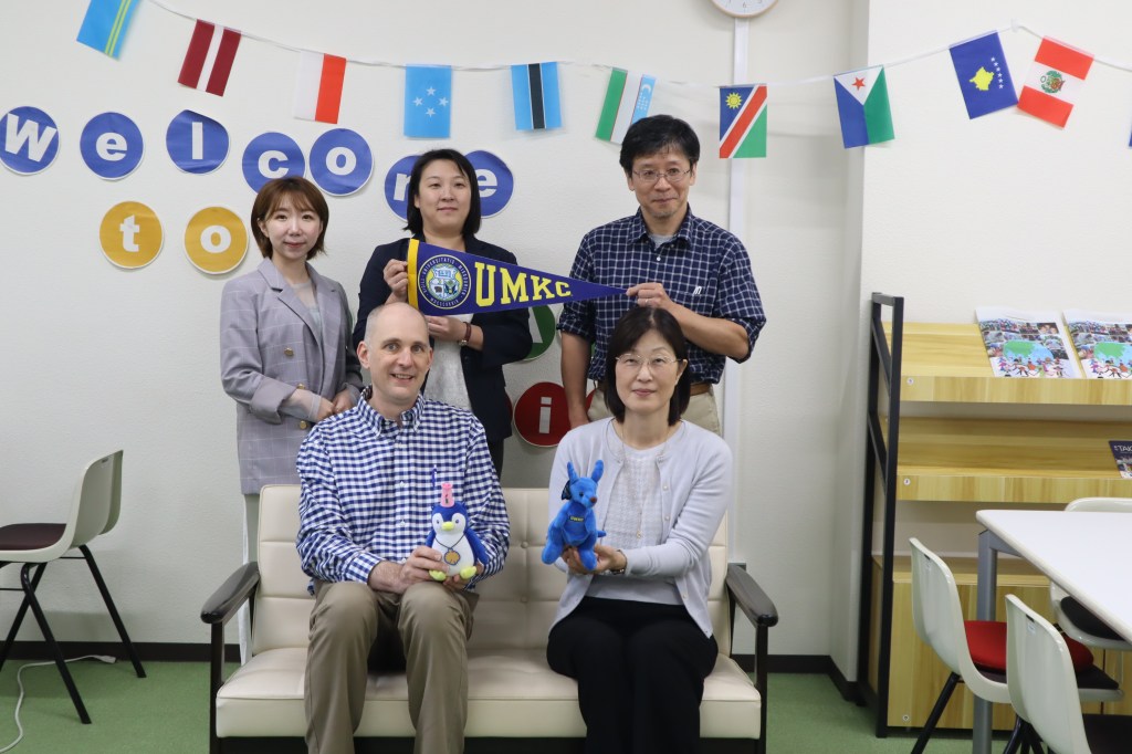 Group photo holding UMKC pennant