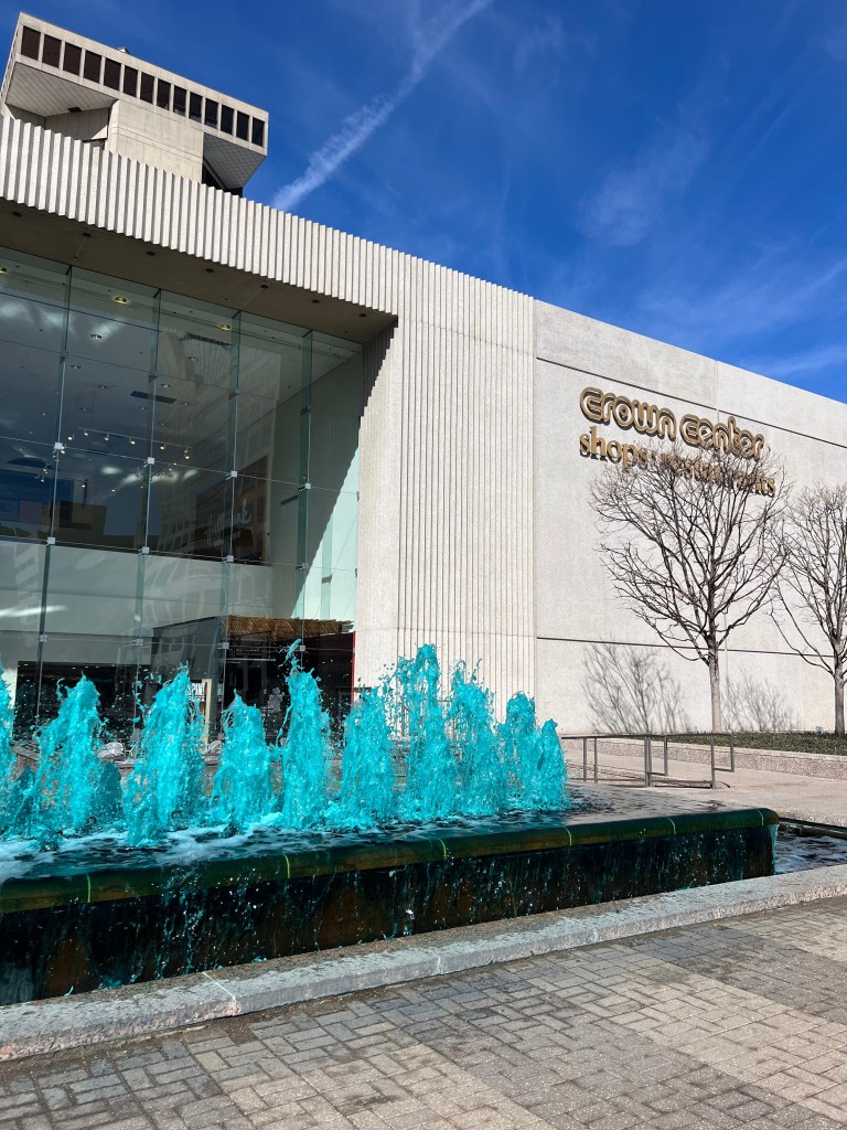 Exterior shot of Crown Center shopping center with dyed blue fountain waters.