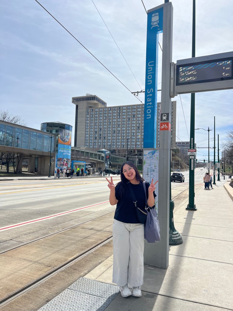 Student holding up peace signs in front of Union Station Streetcar stop