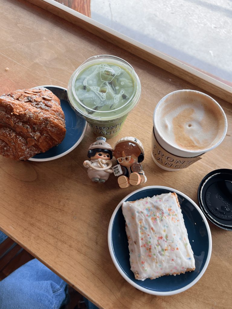 Image of a matcha, hot latte and pastries on a countertop.