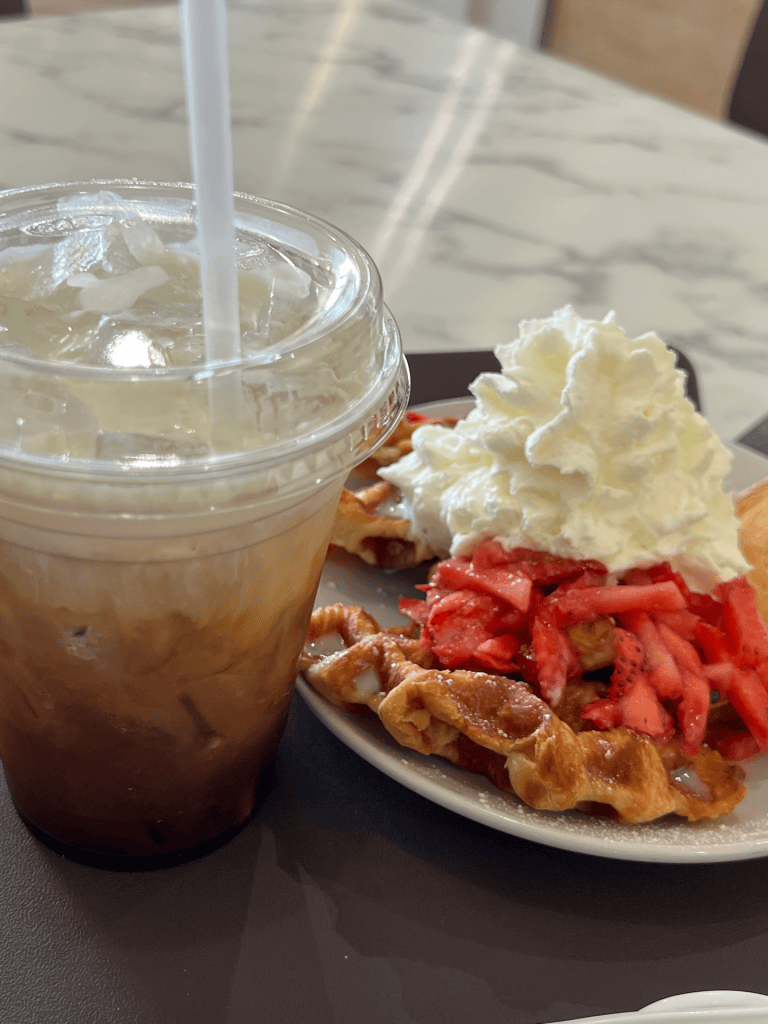 Coffee and strawberry croffle on a table.