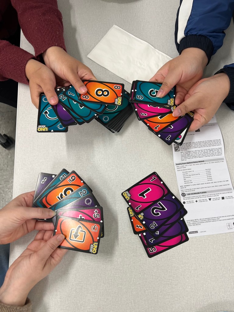 UNO FLIP! cards in 4 hands.